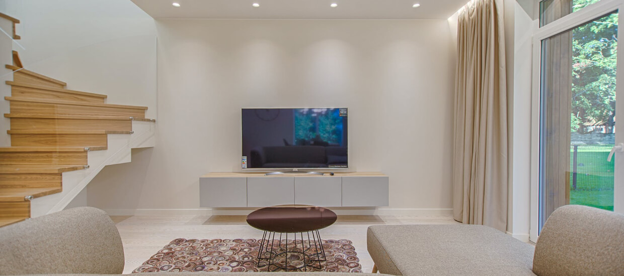 Modern TV lounge with wooden stairs and elegant interior design